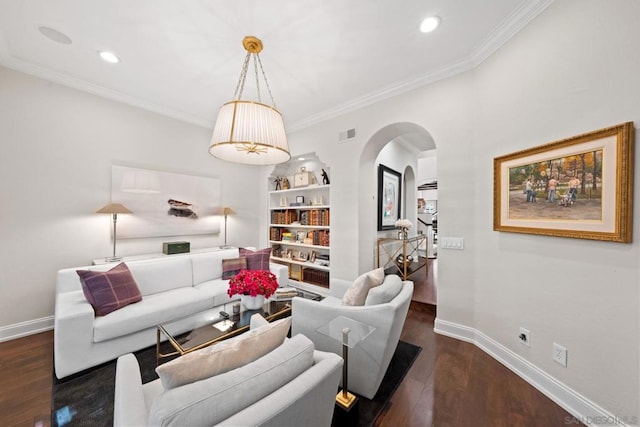 living room with dark hardwood / wood-style flooring, crown molding, and built in shelves