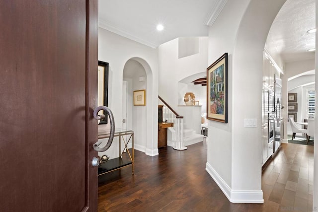 entrance foyer with crown molding and dark wood-type flooring