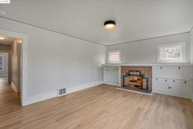 unfurnished living room featuring a fireplace and light hardwood / wood-style floors