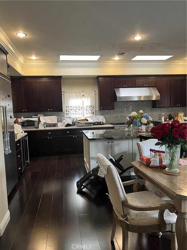 kitchen with ornamental molding, dark hardwood / wood-style floors, and dark brown cabinets