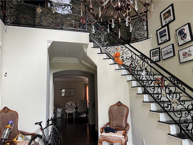 staircase featuring a high ceiling and crown molding