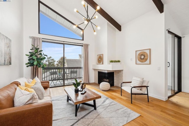 living room featuring a fireplace, a notable chandelier, wood-type flooring, and beamed ceiling