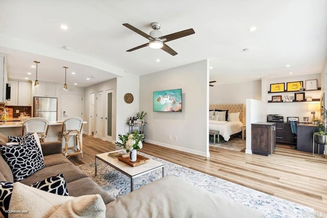 living room with ceiling fan and light wood-type flooring