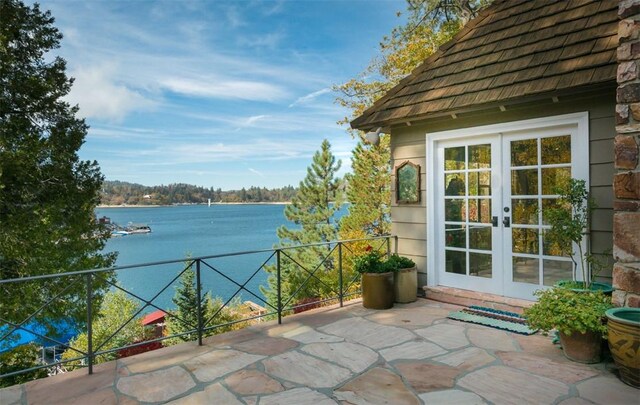 view of patio / terrace with french doors and a water view