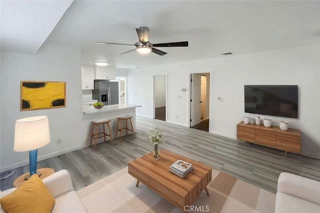 living room with ceiling fan and light hardwood / wood-style floors