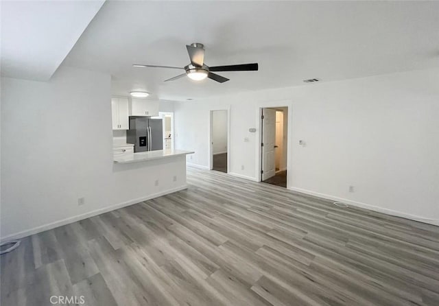 unfurnished living room with ceiling fan and light wood-type flooring