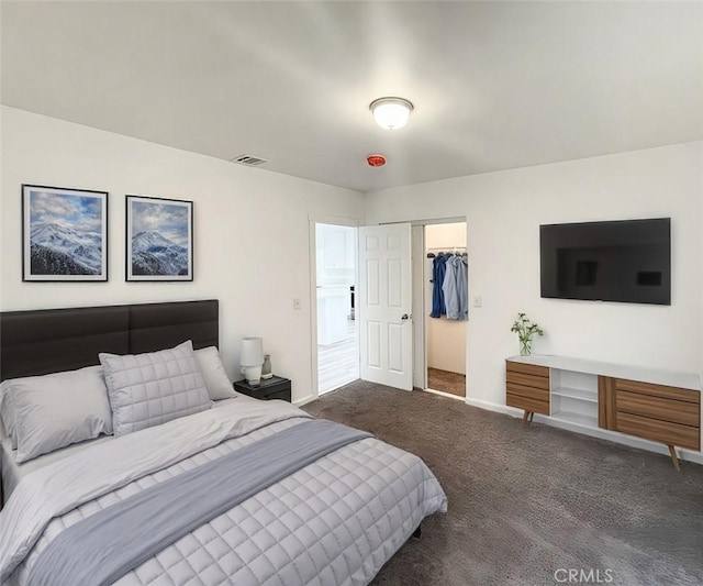 carpeted bedroom with a walk in closet and a closet