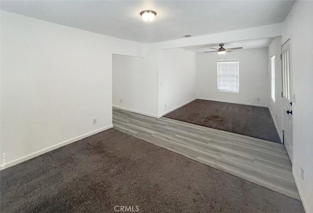 unfurnished room featuring dark wood-type flooring and ceiling fan