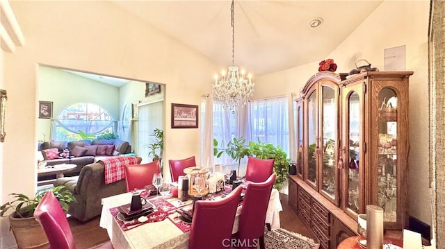 dining space with hardwood / wood-style flooring, a wealth of natural light, high vaulted ceiling, and a chandelier