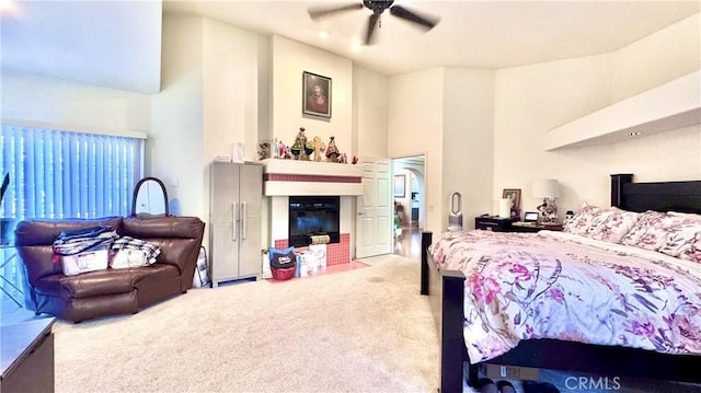 bedroom with ceiling fan, a towering ceiling, and carpet