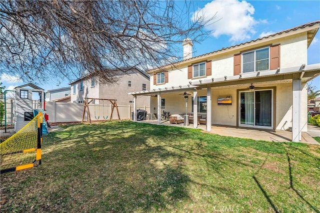 rear view of property featuring a yard, a patio, and ceiling fan