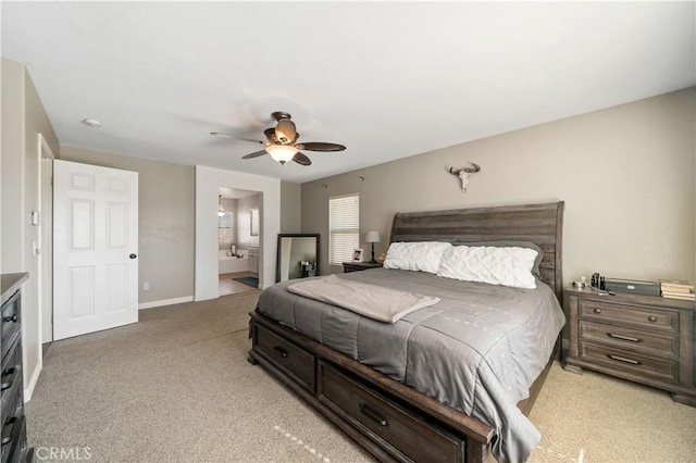 bedroom with light colored carpet, ceiling fan, and ensuite bathroom