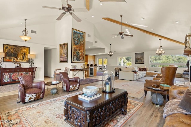 living room featuring high vaulted ceiling, beverage cooler, ceiling fan with notable chandelier, and light wood-type flooring