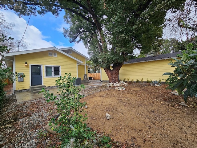 back of property with central AC unit and a patio area