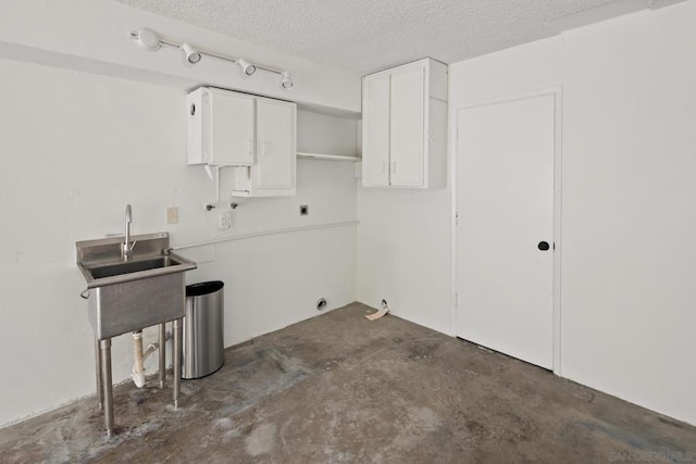 laundry room with cabinets, sink, hookup for an electric dryer, and a textured ceiling