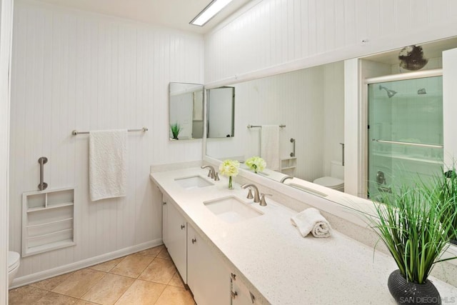 bathroom featuring tile patterned flooring, vanity, a shower with door, and toilet