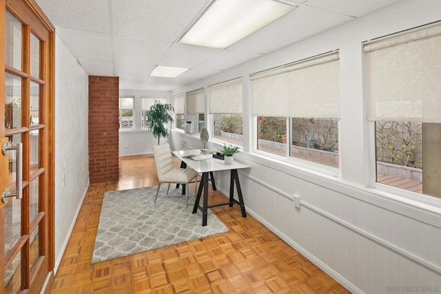 office area with a drop ceiling and light parquet flooring