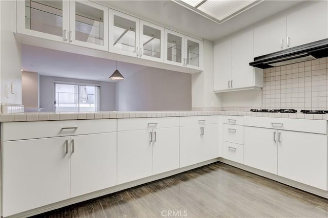 kitchen featuring white gas stovetop, white cabinetry, and decorative light fixtures