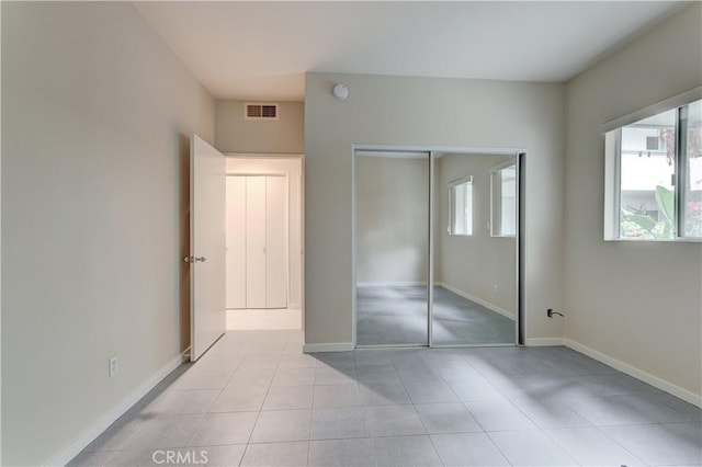 unfurnished bedroom featuring light tile patterned flooring and a closet