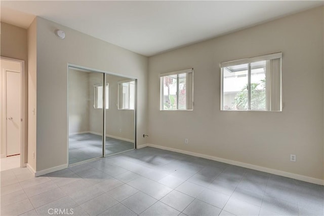 unfurnished bedroom with light tile patterned floors and a closet