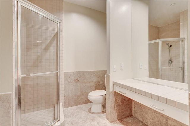 bathroom featuring walk in shower, toilet, tile patterned flooring, and tile walls