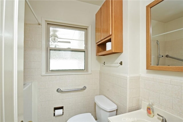 bathroom with tile walls and toilet