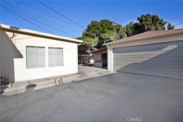 view of side of home featuring a garage and an outbuilding