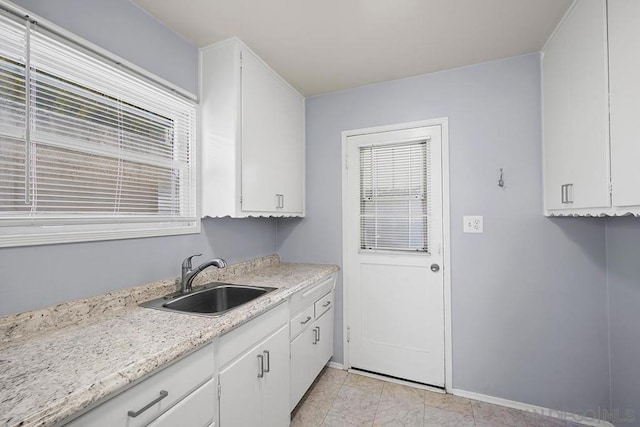 kitchen featuring white cabinetry and sink