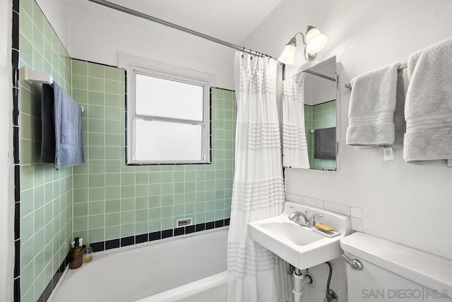 full bathroom featuring toilet, shower / bathtub combination with curtain, and sink