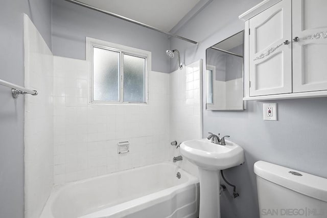 full bathroom featuring tiled shower / bath, sink, and toilet