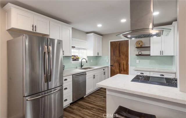 kitchen with island exhaust hood, appliances with stainless steel finishes, sink, and white cabinets