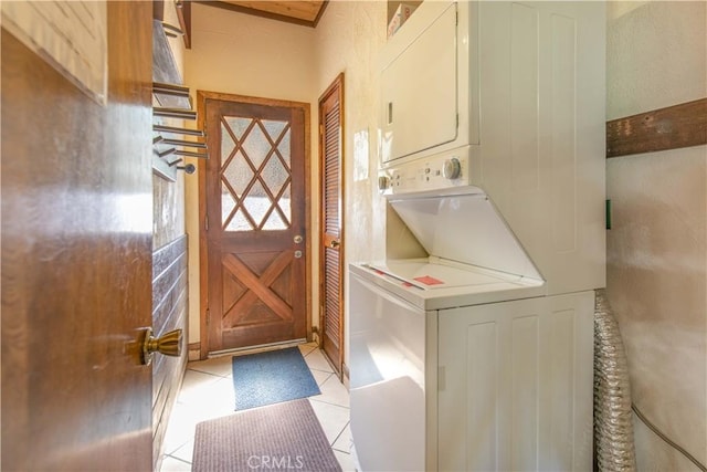 washroom featuring stacked washer / dryer and light tile patterned floors