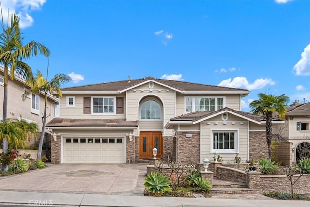 view of front of home featuring stone siding, concrete driveway, and an attached garage