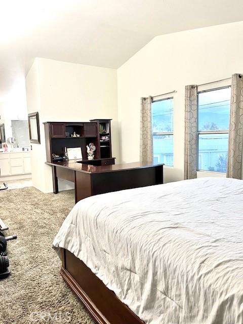 carpeted bedroom with vaulted ceiling