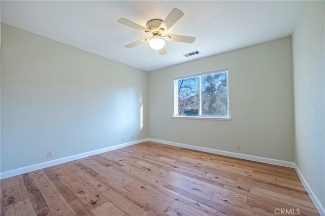 spare room with light wood-style floors, visible vents, baseboards, and a ceiling fan