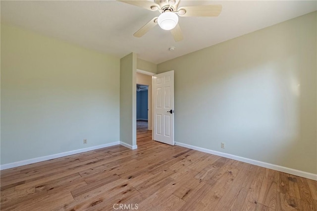 unfurnished room with baseboards, light wood finished floors, and a ceiling fan