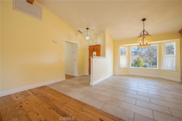 unfurnished dining area with light tile patterned floors, vaulted ceiling, visible vents, a chandelier, and baseboards