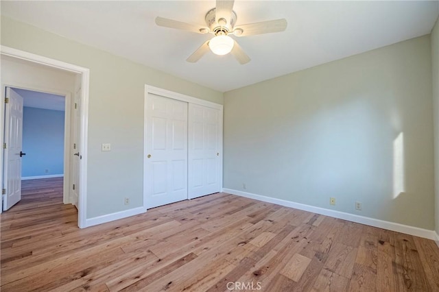 unfurnished bedroom featuring a closet, baseboards, and light wood-style floors