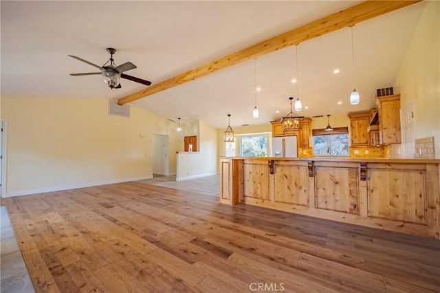 kitchen featuring fridge with ice dispenser, decorative light fixtures, a peninsula, light wood-style floors, and vaulted ceiling with beams