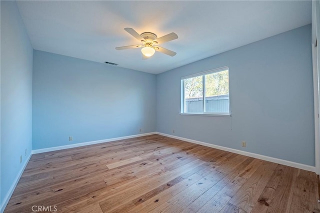 spare room with ceiling fan, light wood-style flooring, visible vents, and baseboards