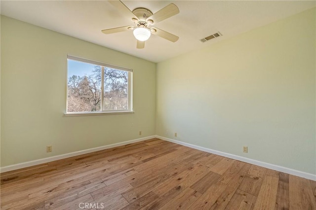 spare room with visible vents, baseboards, a ceiling fan, and wood finished floors