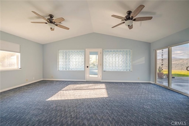 spare room with vaulted ceiling, dark carpet, baseboards, and ceiling fan