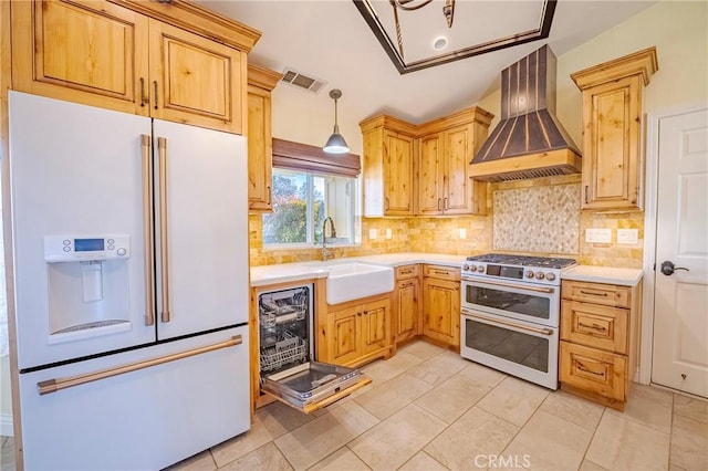 kitchen with visible vents, a sink, wall chimney range hood, double oven range, and white refrigerator with ice dispenser