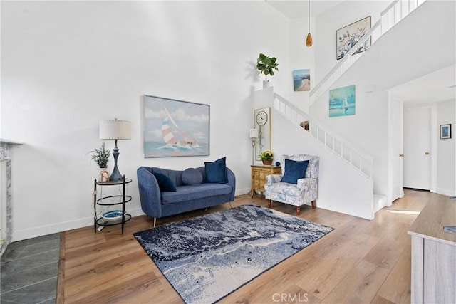 living room featuring a towering ceiling and hardwood / wood-style floors