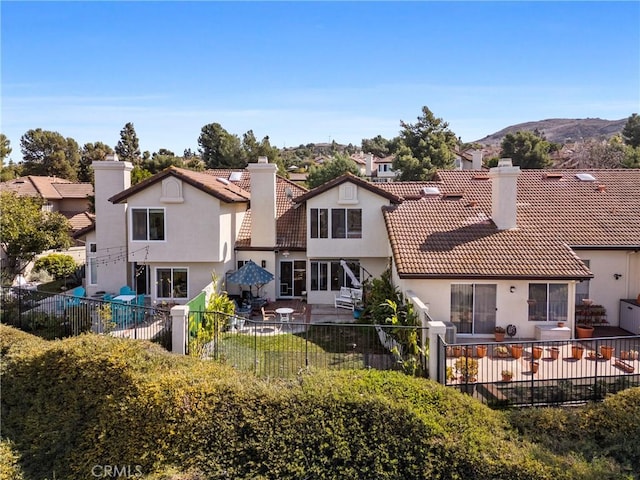 rear view of house with a mountain view and a patio area