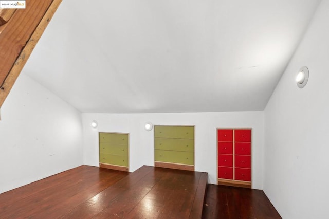 additional living space featuring lofted ceiling and dark hardwood / wood-style flooring