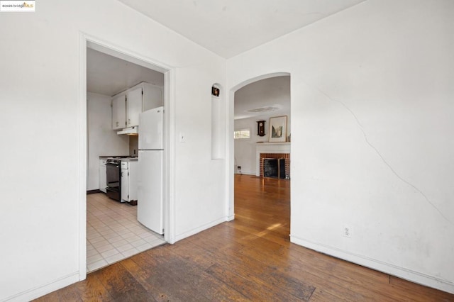 empty room featuring a fireplace and light hardwood / wood-style flooring