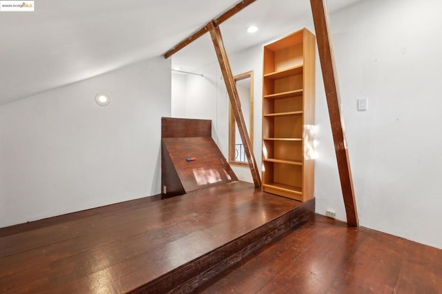 additional living space with vaulted ceiling and dark wood-type flooring