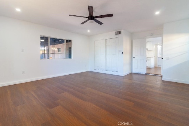 unfurnished bedroom featuring ceiling fan, dark hardwood / wood-style flooring, and a closet