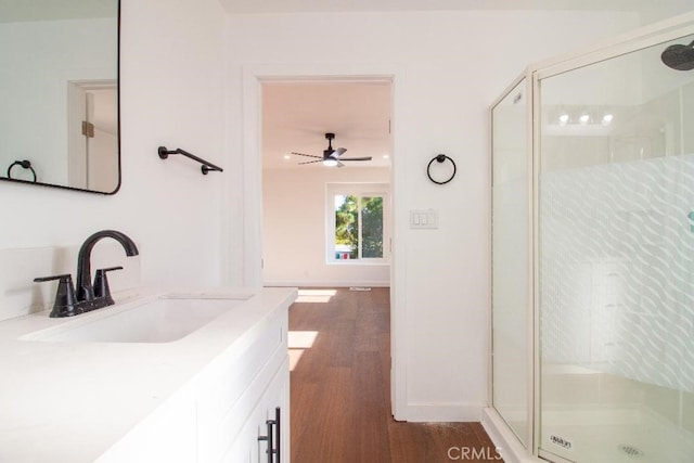 bathroom with hardwood / wood-style flooring, vanity, an enclosed shower, and ceiling fan